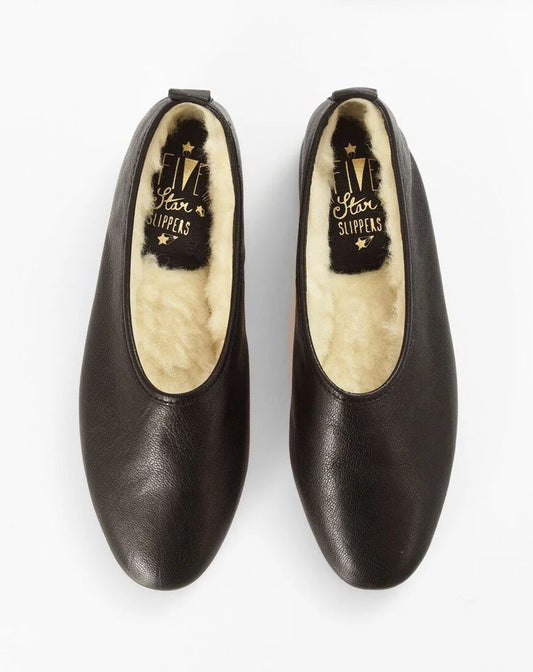 A pair of black leather slip-on shoes with a cream-colored shearling lining, shown from a top-down view on a white background. The brand name 'Five Star Slippers' is visible on the insole.