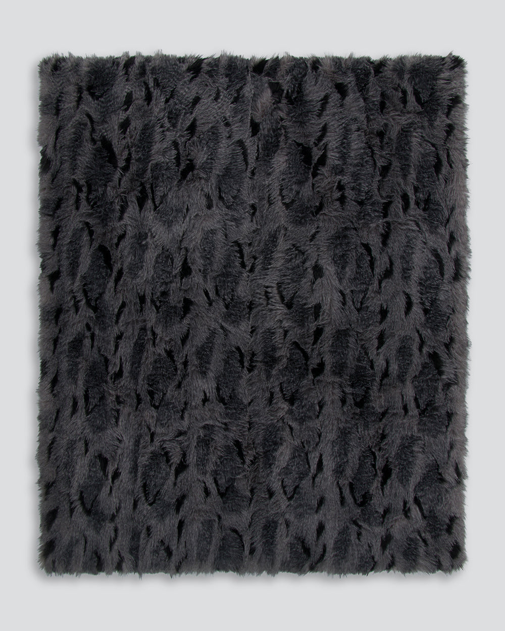 Dark gray textured fur throw on a light gray background