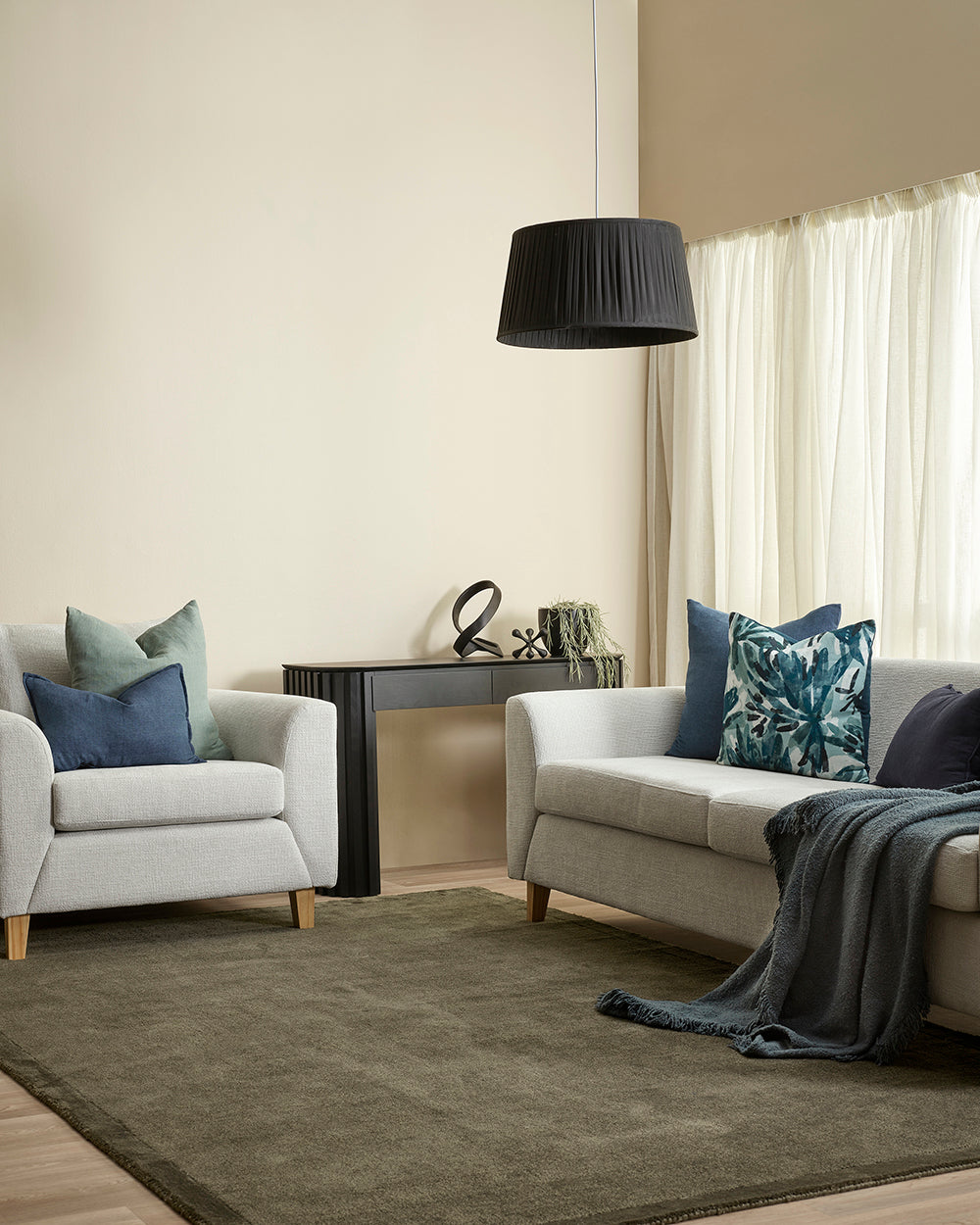 Living room with gray sofa, armchair, and decorative pillows.