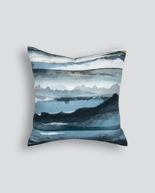 Decorative pillow with a watercolor landscape design on a light gray background