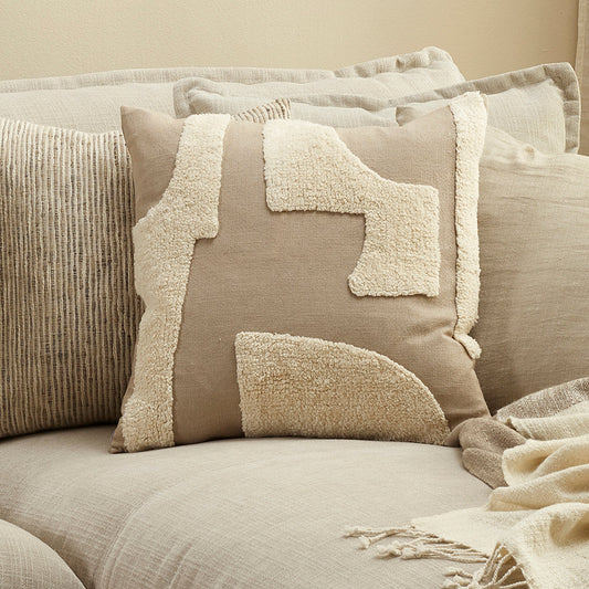 Neatly arranged pillows on a sofa with a neutral color scheme.