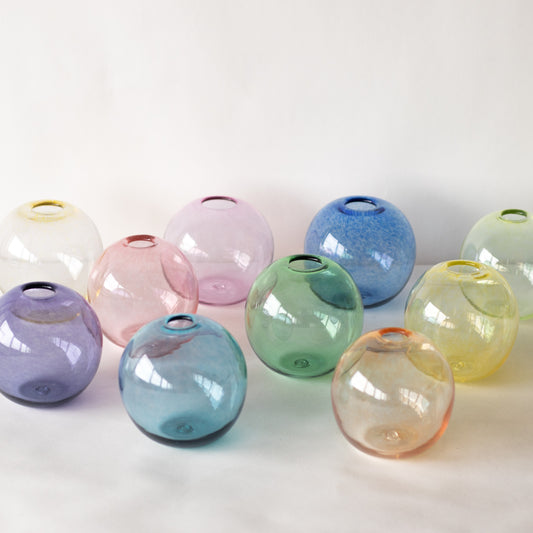 group of spherical clear hand blown glass bud vases in blue, green, pink, yellow and orange