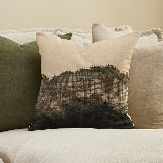 Decorative pillow with gradient pattern on a sofa against a beige wall