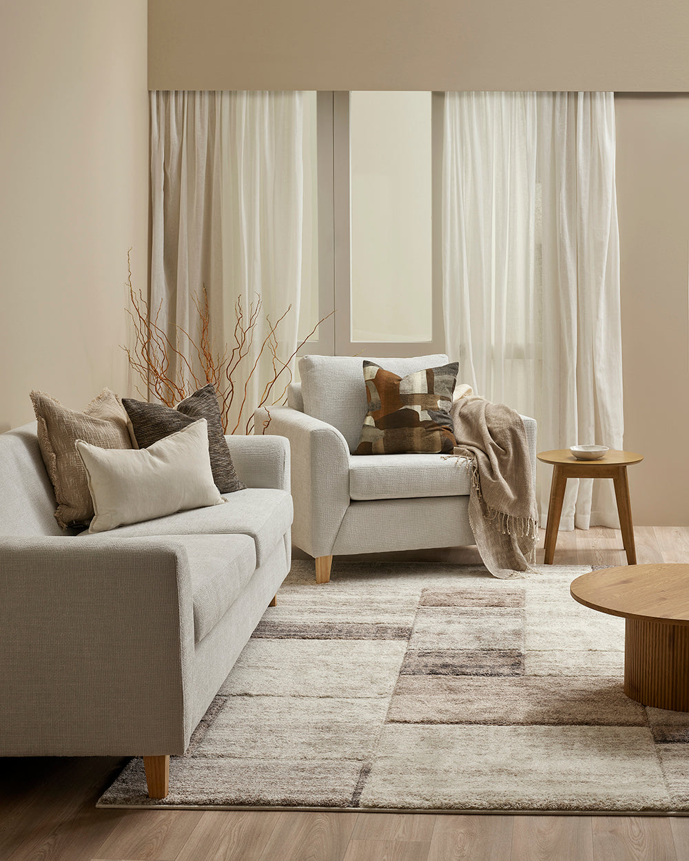 Living room with beige sofas, decorative pillows, and a wooden coffee table.