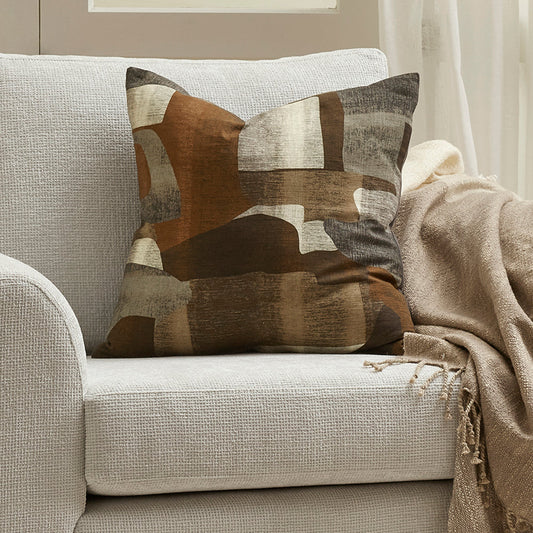 Decorative pillow with abstract pattern on a beige sofa