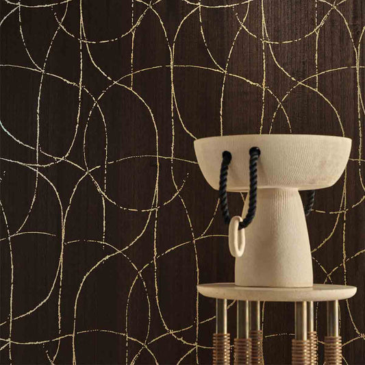 White ceramic bowl with black rope handle on a stand against a dark wall with gold circular patterns