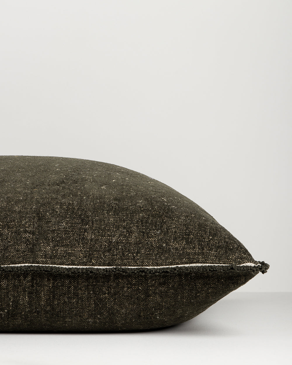 Textured black pillow on a light gray background