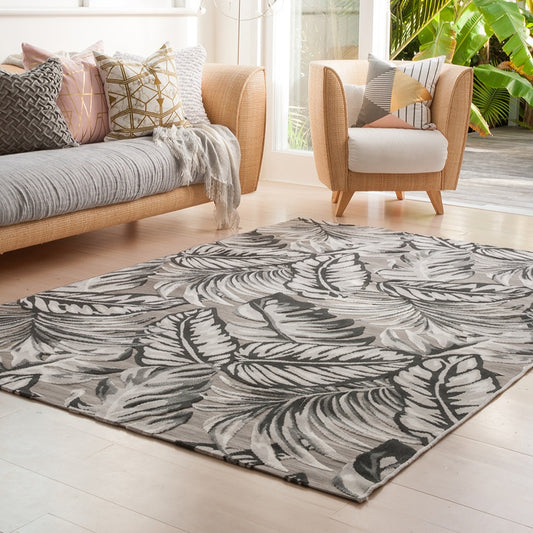 Figuig rug on floor with sofa and chair and cushions with garden door opened to foilage