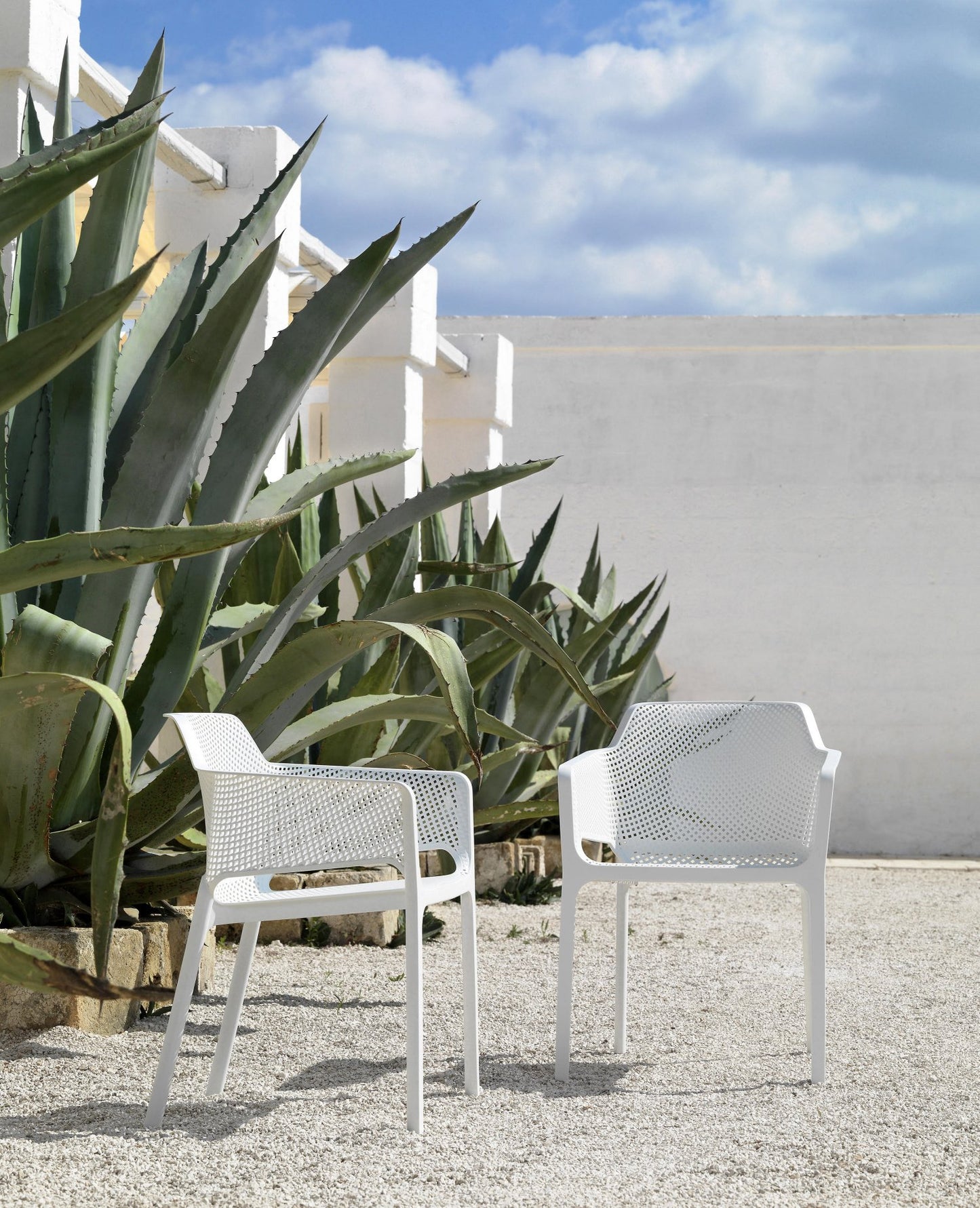 2 white nardi net charis in a white walled garden