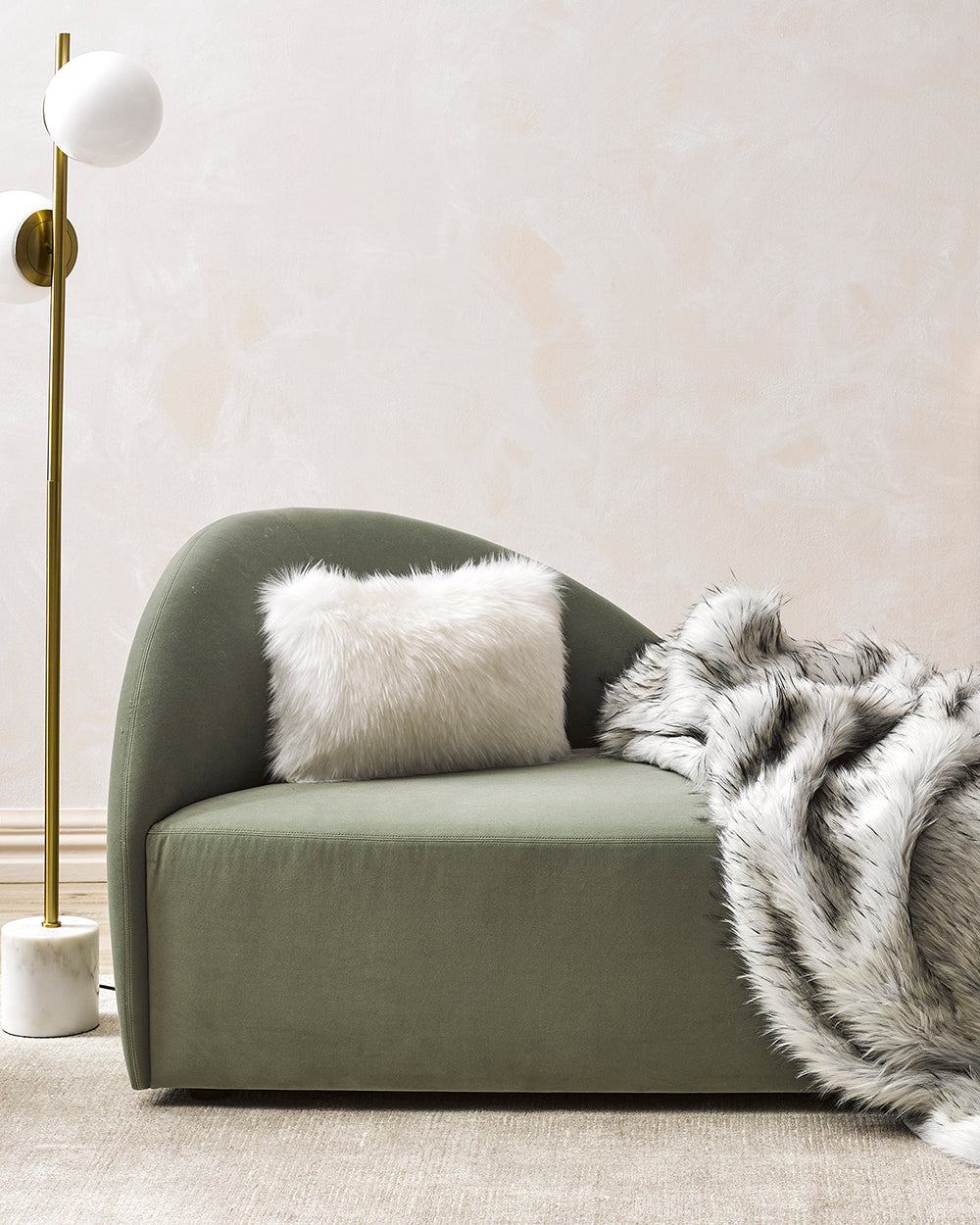 Norwegian fox imitation fur cushion on a green sofa with white stand light