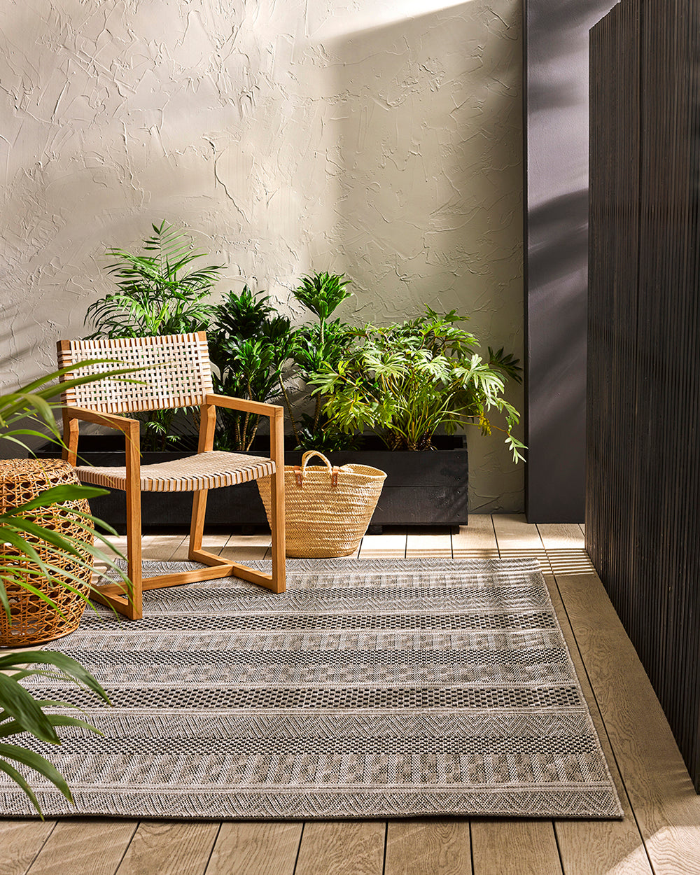 Peru outdoor rug with a chair and basket alongside with foliage in the background