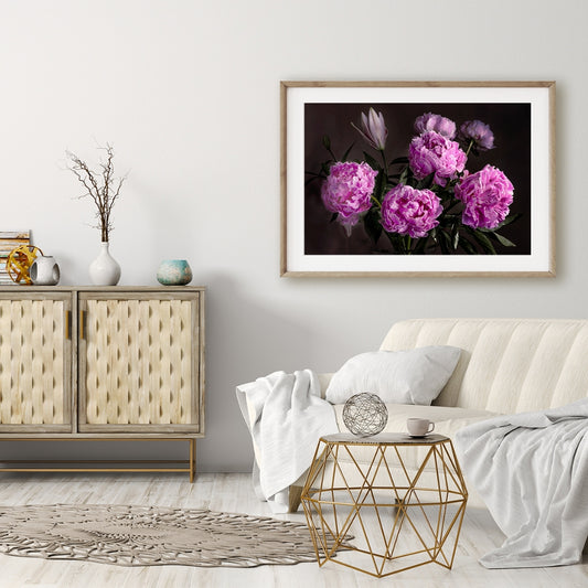pink peonies wall art in a white lounge with white sofa, cushions and throws and a grey side cabinet with grey vases on top and grey wall. Gold wire coffee table