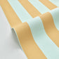 A close-up of a striped material with alternating wide bands of pale mint green and warm peach-beige, shown folded over on a light neutral background.