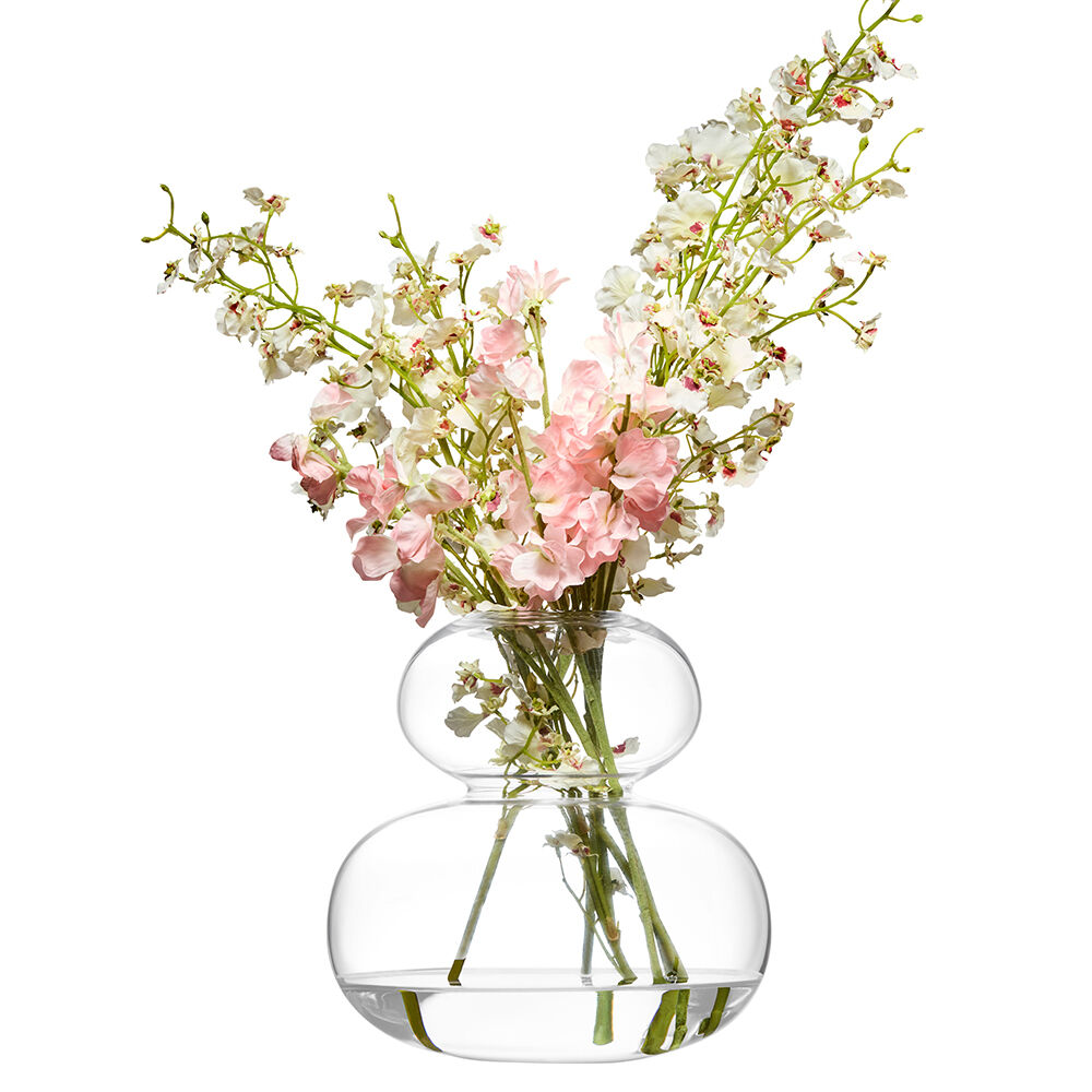 Clear glass vase with a bouquet of pink and white flowers on a white background