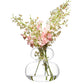 Clear glass vase with a bouquet of pink and white flowers on a white background
