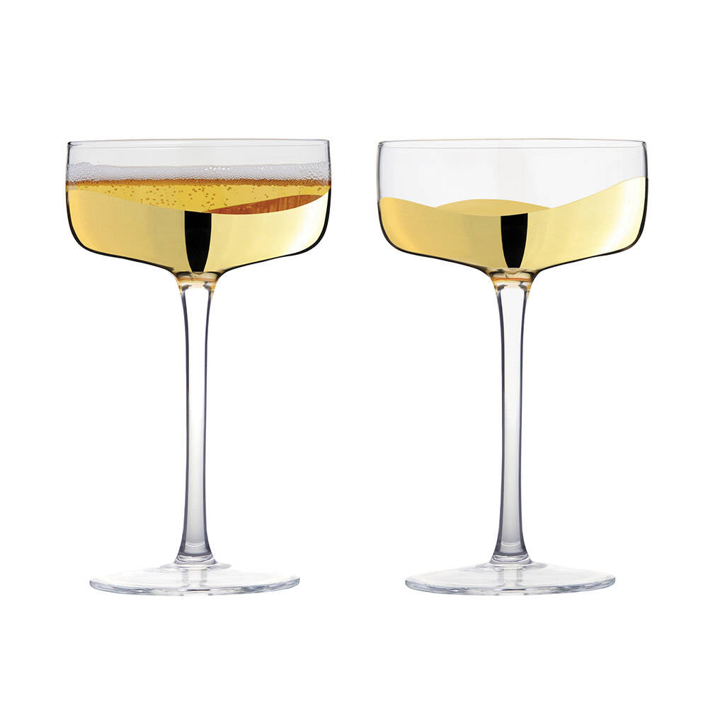 Two champagne glasses filled with champagne on a white background