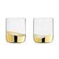 Two clear glasses with gold accents on a white background