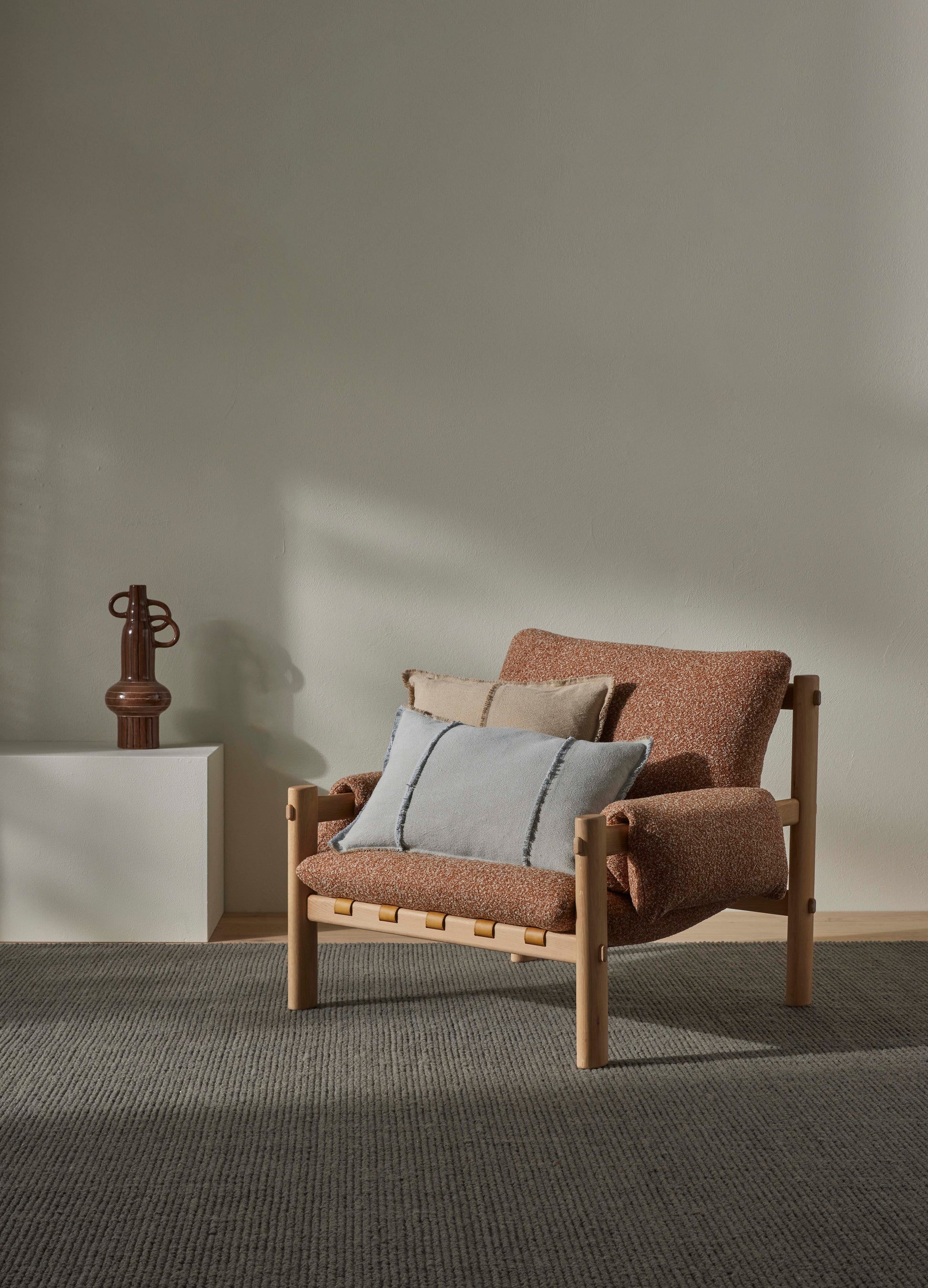 Brown armchair with cushions in a minimalistic room