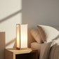 Table lamp on a bedside table with soft lighting in a bedroom setting