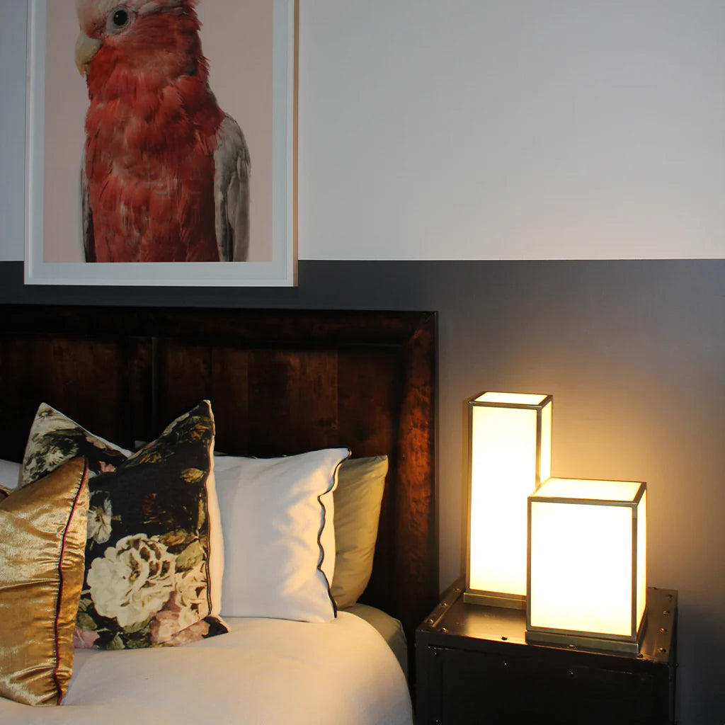 two rectangle alabaster lamps sitting beside a bed