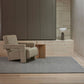 Alessandre rug in blue grey with a modern beige architectural chair on it