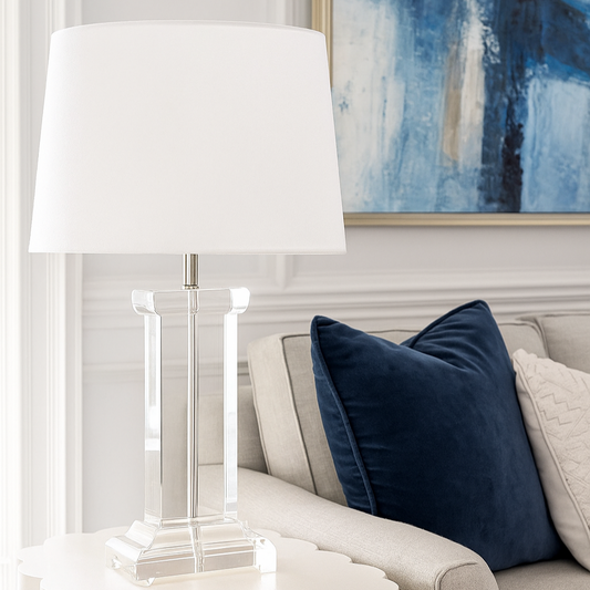Living room with beige sofa, blue pillows, and a glass lamp.
