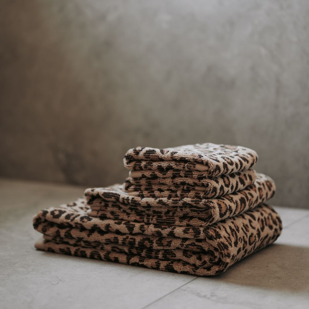 Stack of leopard print towels on a neutral background