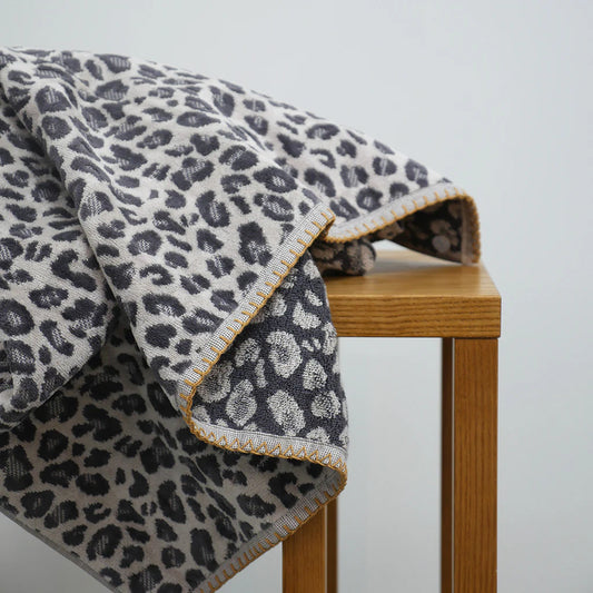 Animal print towel draped over wooden stool