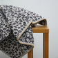 Animal print towel draped over wooden stool