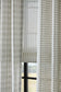 Sheer checkered curtain with a blurred outdoor view in the background