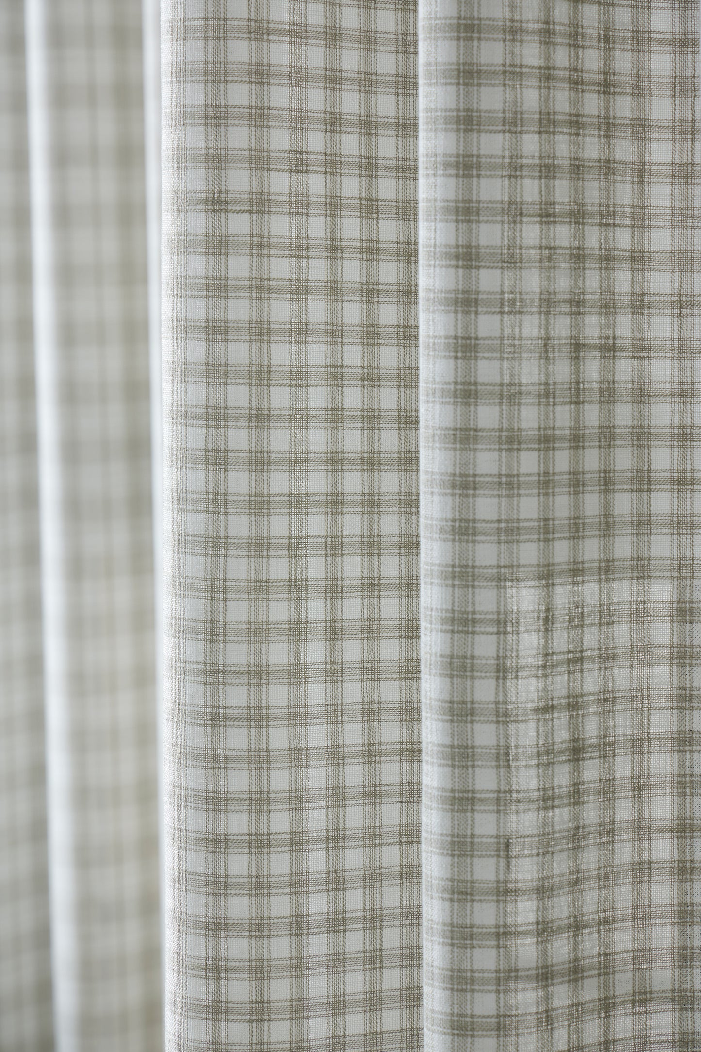 Close-up of a fabric with a plaid pattern in neutral colors.