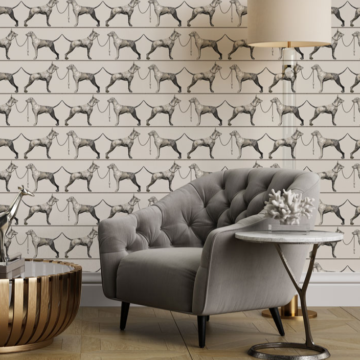 Gray armchair in a room with patterned wallpaper featuring dog  illustrations.
