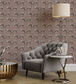 Living room with a gray sofa, side table, and decorative items against a wall with dog patterned wallpaper.