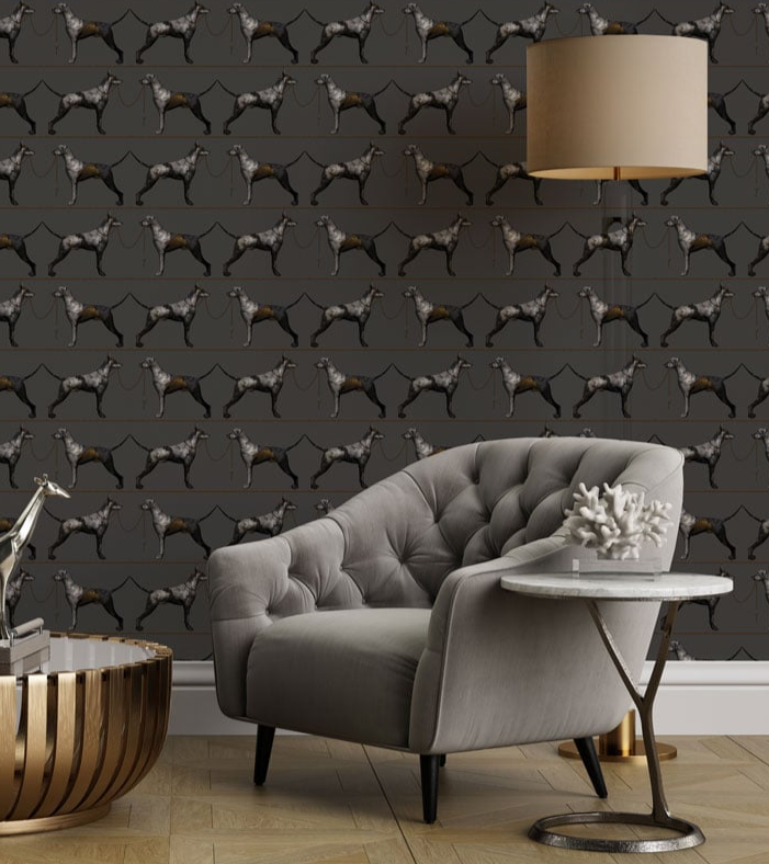 Gray tufted sofa in a room with dark gray walls featuring a dog pattern, a small round table, and decorative items.
