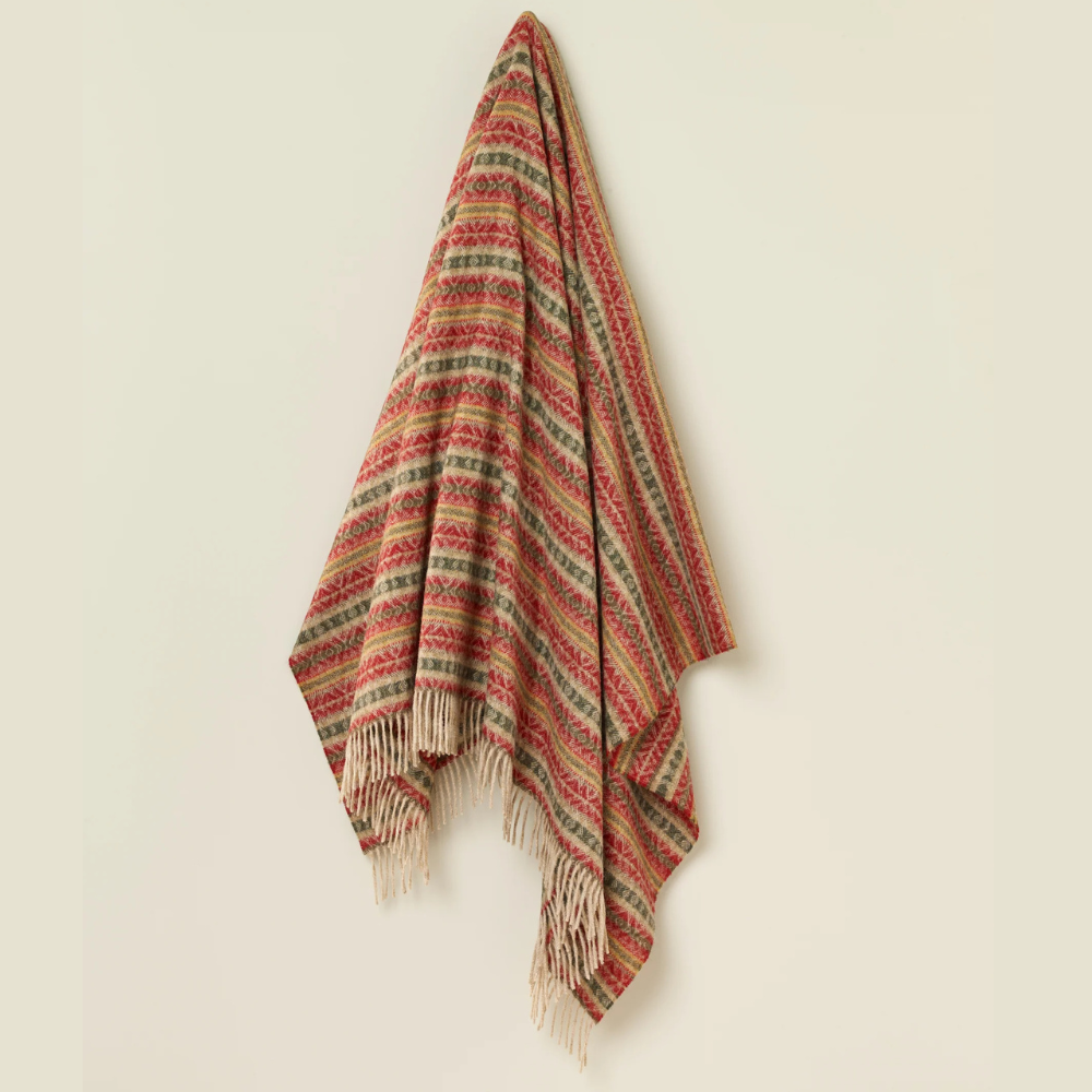 Woven blanket with red and green pattern on a beige background