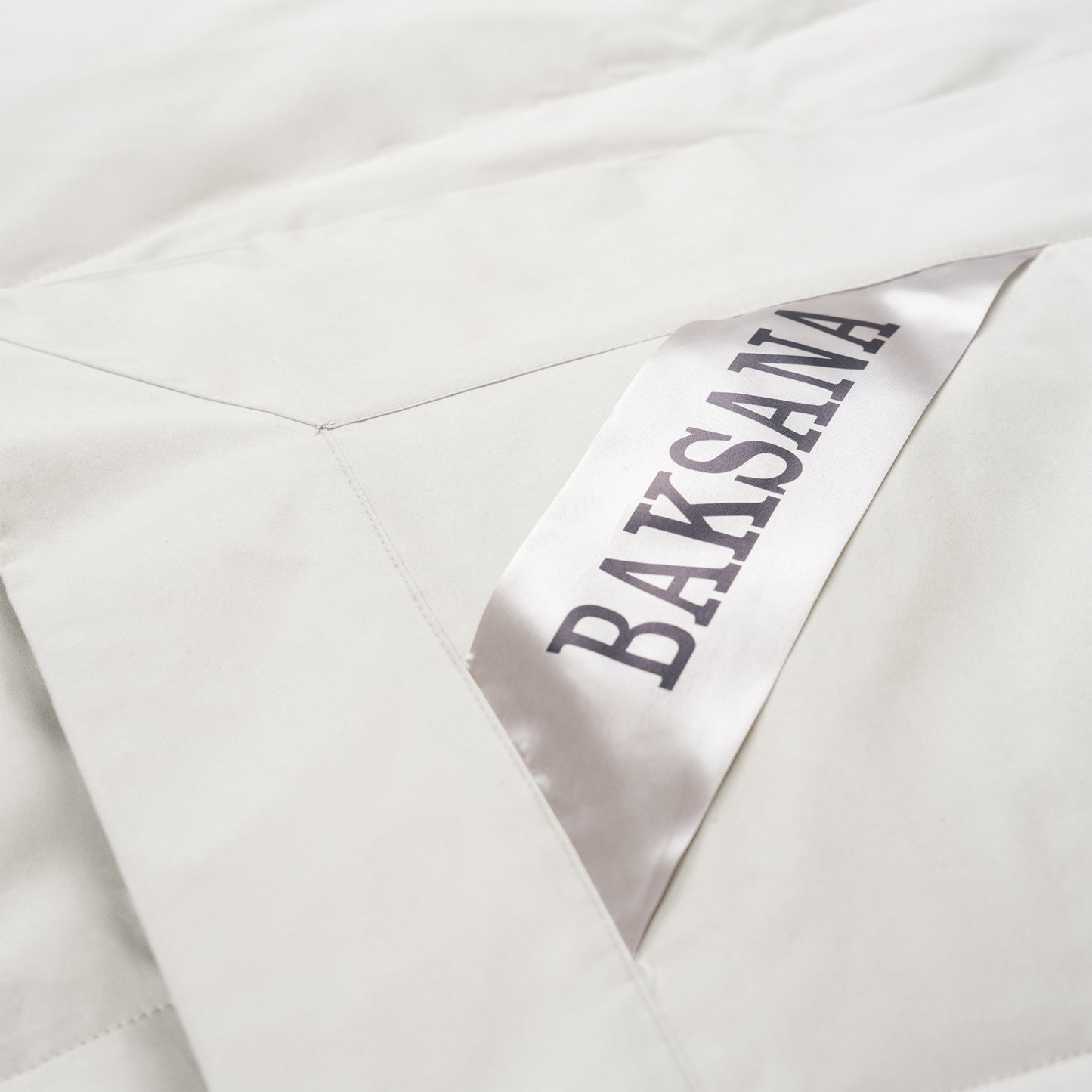 Close-up of a white fabric garment with a satin label reading BAKSANA in dark lettering.