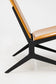 Close-up of a chair with black metal frame and beige cushion on a white background