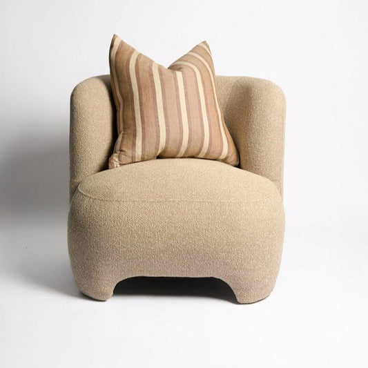 Beige armchair with a striped pillow on a white background