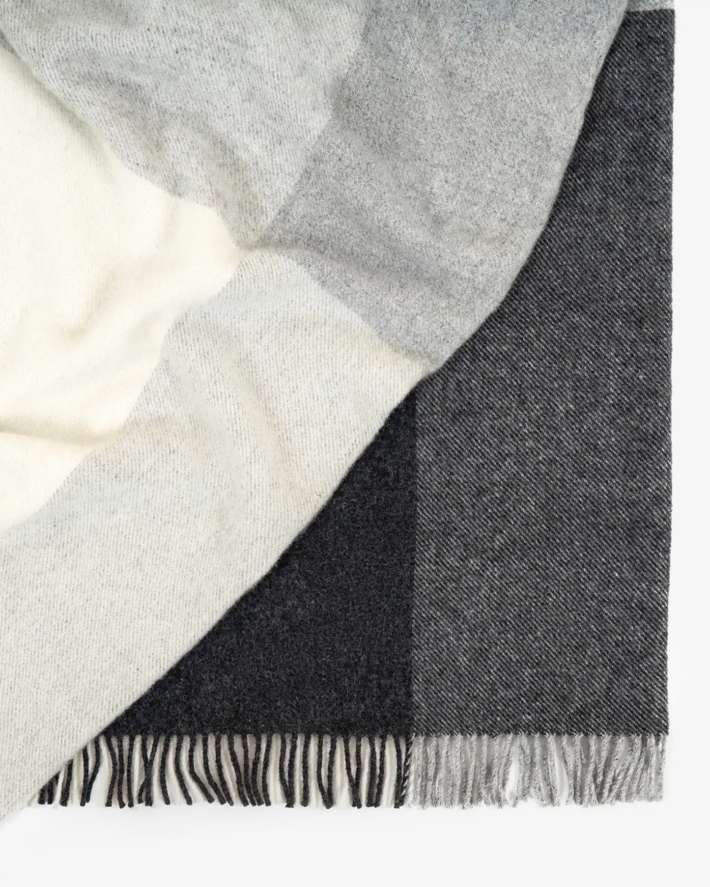 Gray and black checkered blanket with fringed edges on a white background