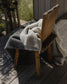 Wooden chair with a blanket draped over it on a wooden deck