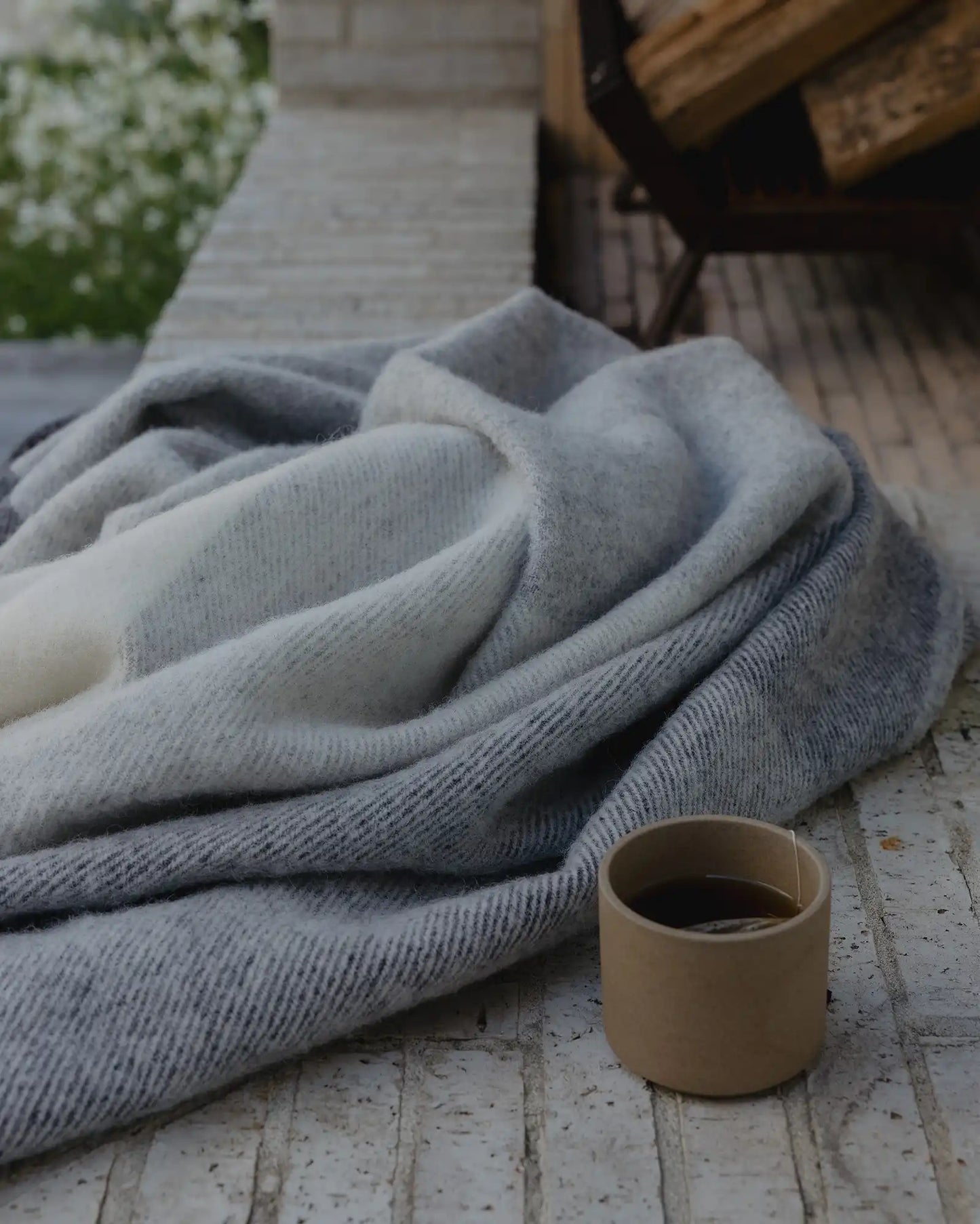 Gray blanket draped over a surface with a small brown container nearby.