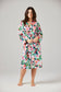 Woman wearing a floral robe against a plain background