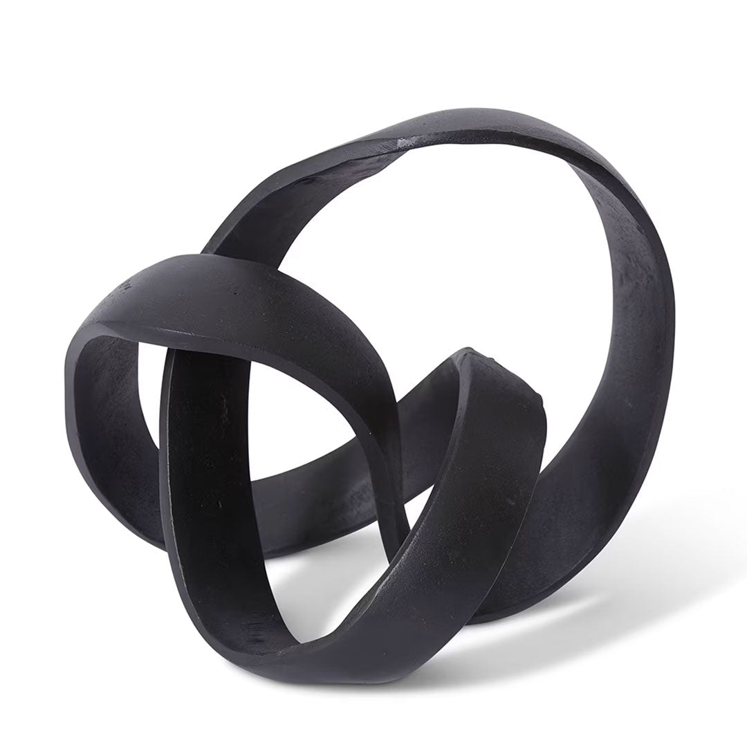 Black abstract sculpture with interlocking loops on a white background