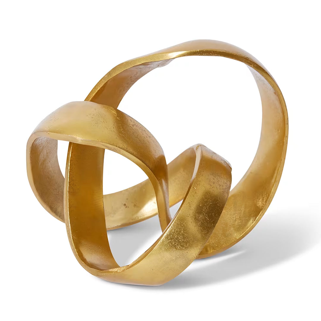 Gold abstract sculpture with interlocking rings on a white background