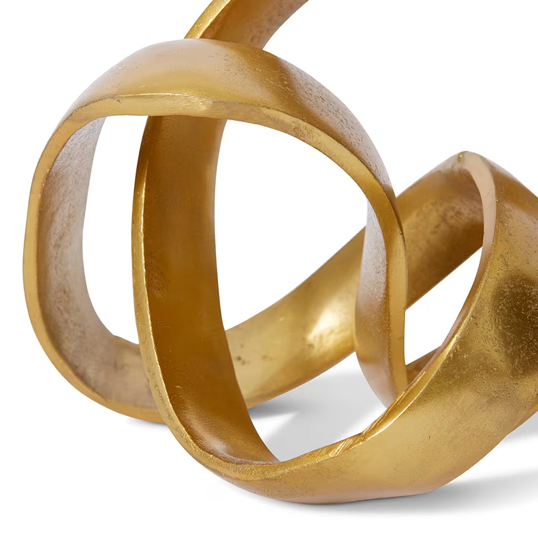 Gold abstract sculpture with interlocking rings on a white background