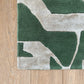 Green and beige abstract patterned rug on a wooden floor