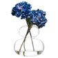 Clear glass vase with blue flowers on a white background