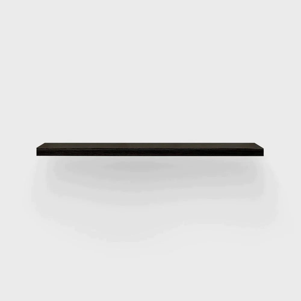 Floating black oak shelf against a white wall