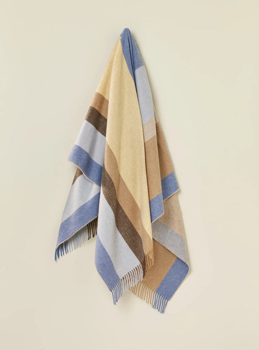Striped blanket with blue, beige, and brown colors on a beige background