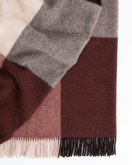 Plaid blanket with brown, gray, and pink colors on a white background